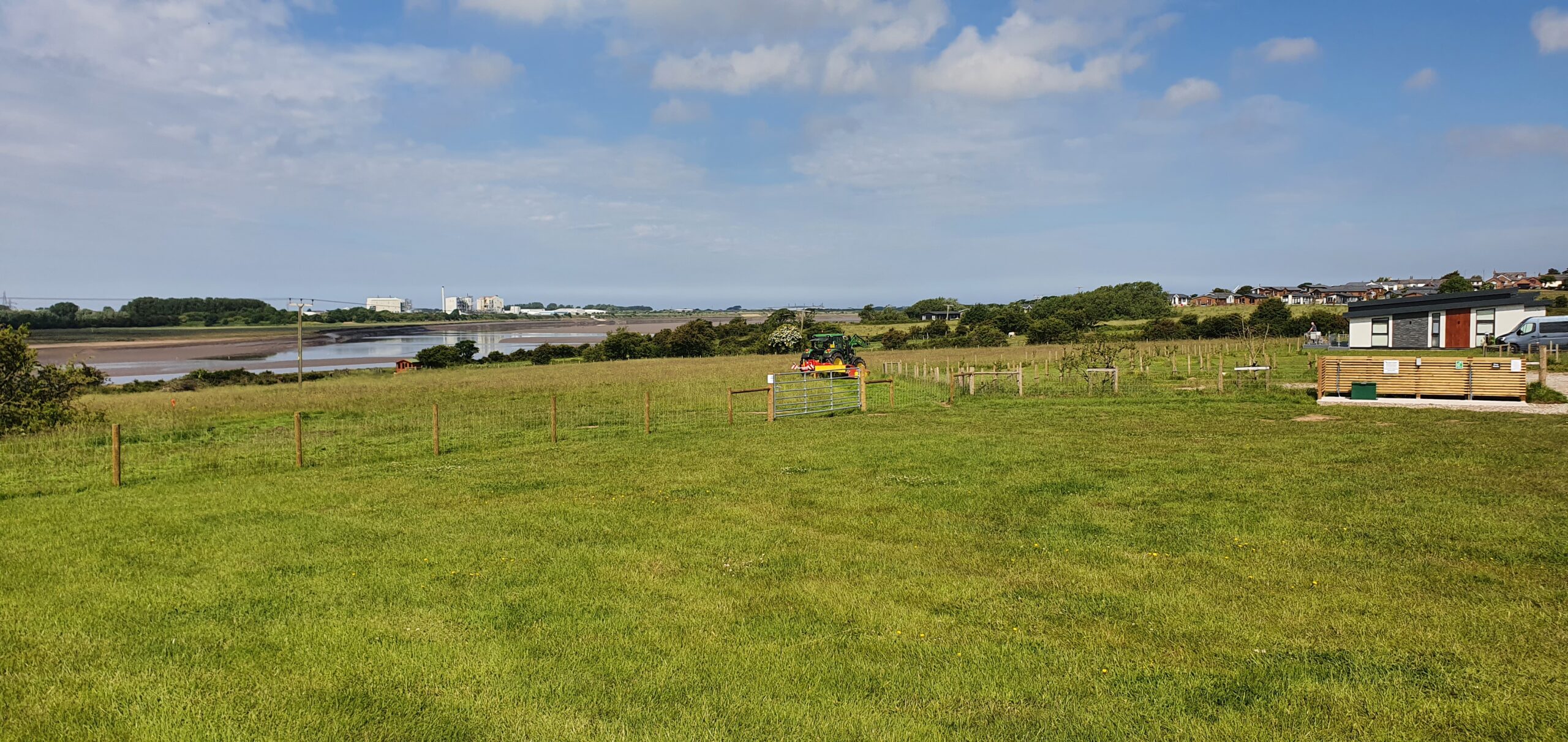 Tractor mowing the field for hay making at The Estuary Riverside Chalets